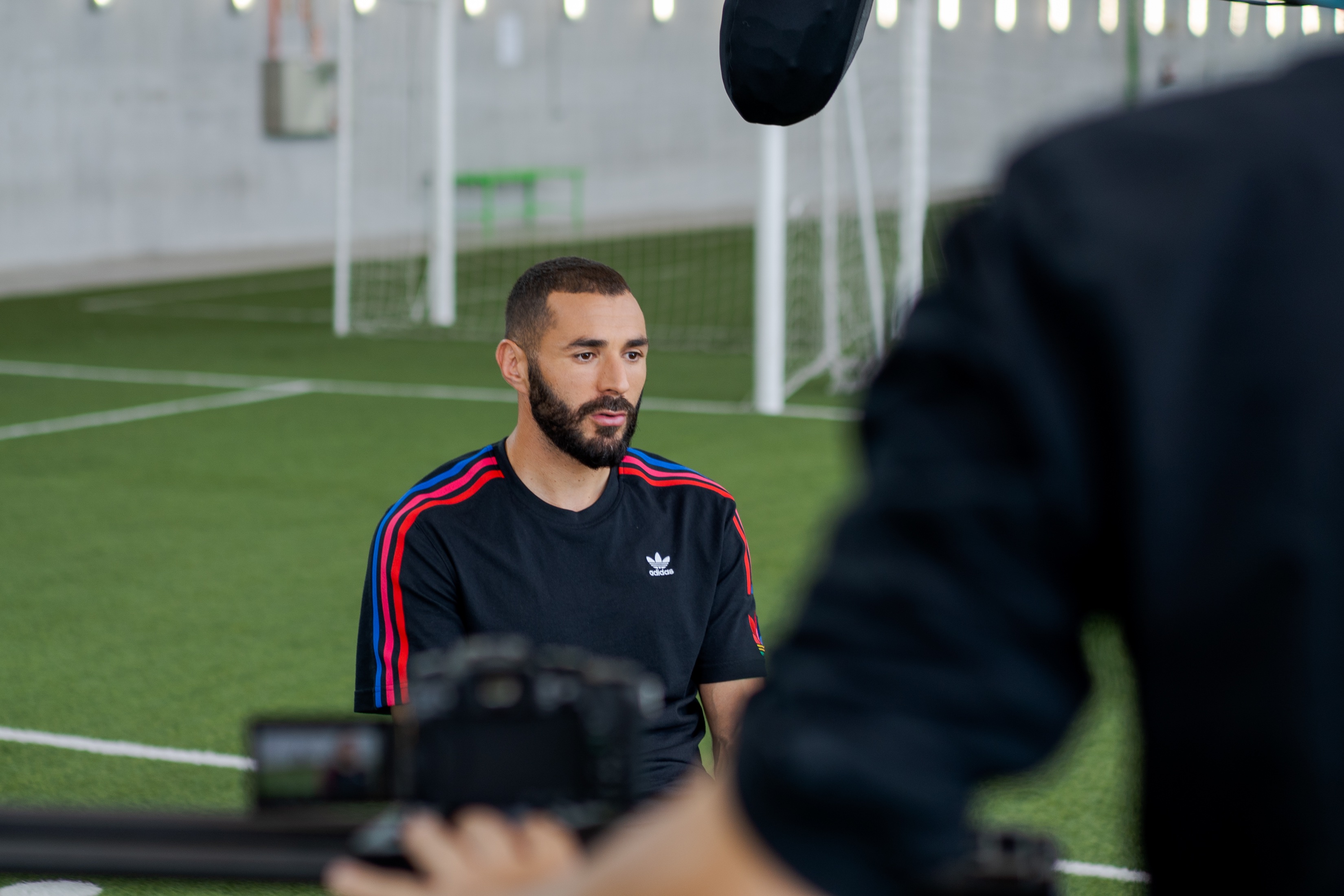 A soccer player is being interviewed on a soccer field